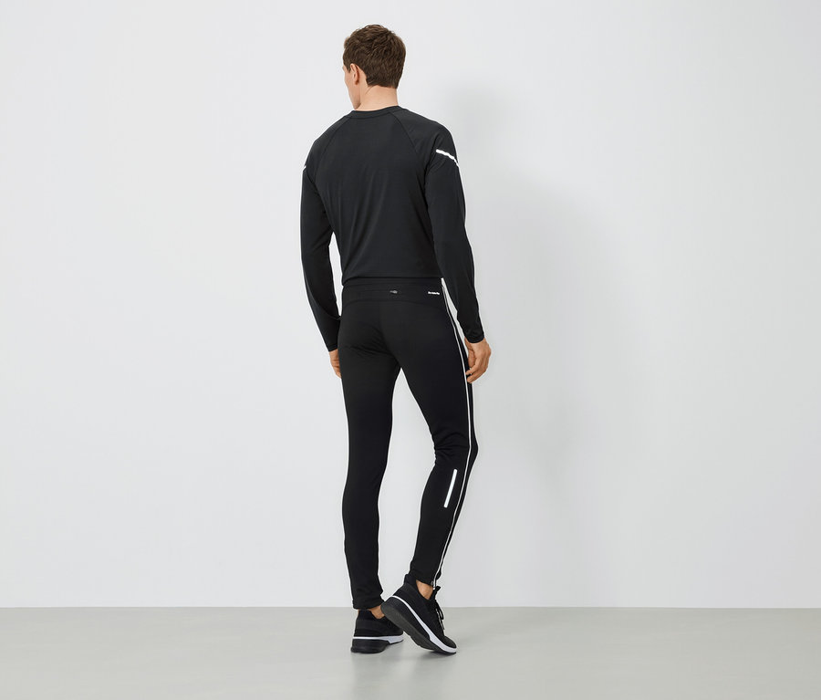 Muž zády k fotoaparátu má na sobě černé sportovní oblečení.