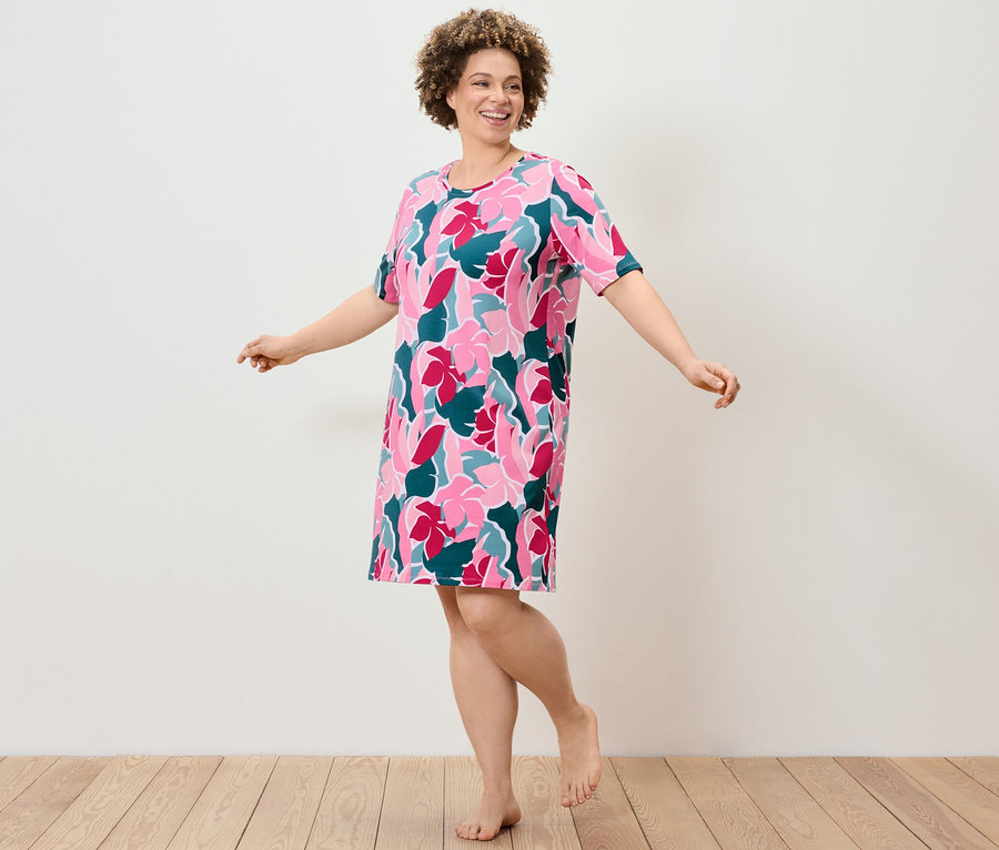 Žena tančí v noční košili s květinovým vzorem.