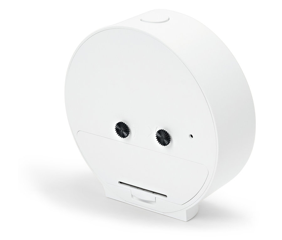 Detail bílého kulatého budíku s knoflíkem nahoře a dvěma knoflíky na zadní straně.