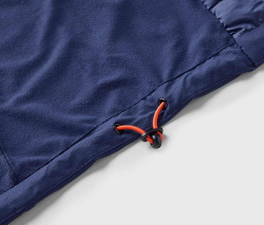 Detailní záběr modré funkční vesty »packable« se stahovací šňůrkou.