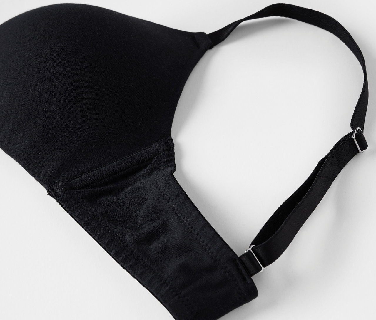 Detail černá podprsenka na bílém pozadí.