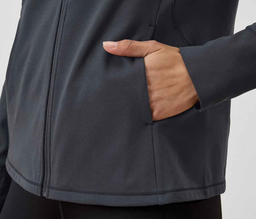 Detailní pohled na šedou mikinu na zip s rukou v kapse.