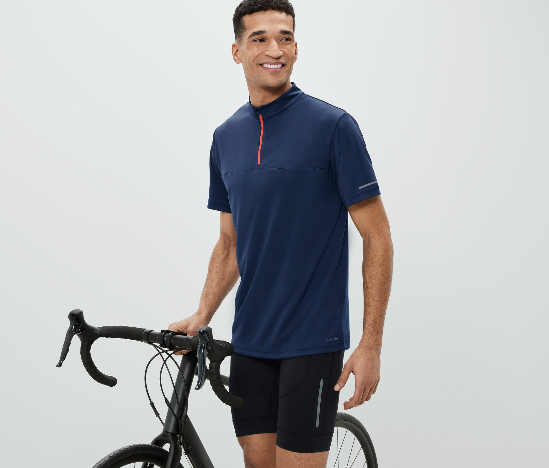 Muž vedle kola má na sobě cyklistický trikot.