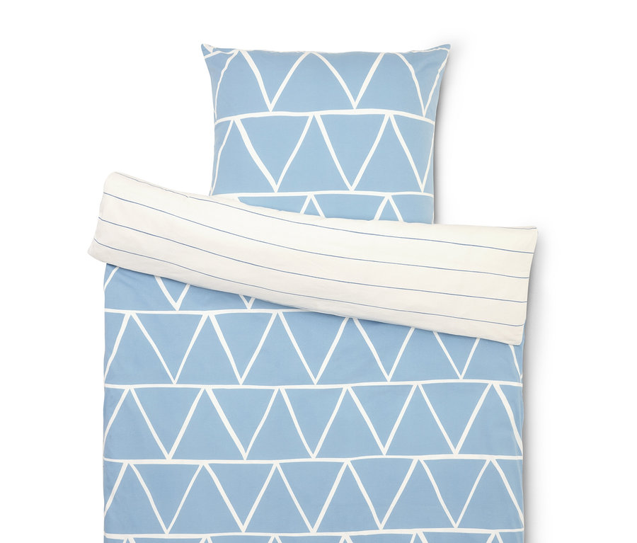Souprava ložního prádla s modrým trojúhelníkovým vzorem a pruhovaným povlakem na polštář.