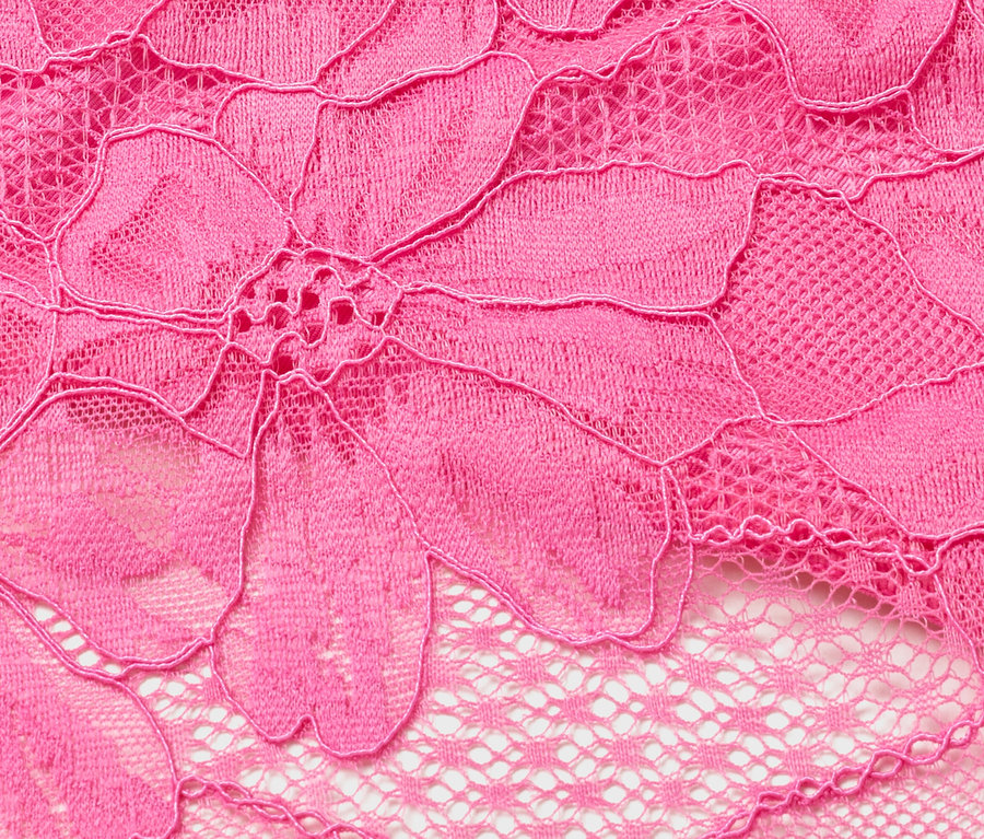 Detail růžové krajky s květinovým vzorem.