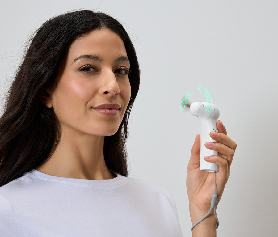 Žena drží bílý, přenosný ventilátor, který zobrazuje slova "Cool Summer".