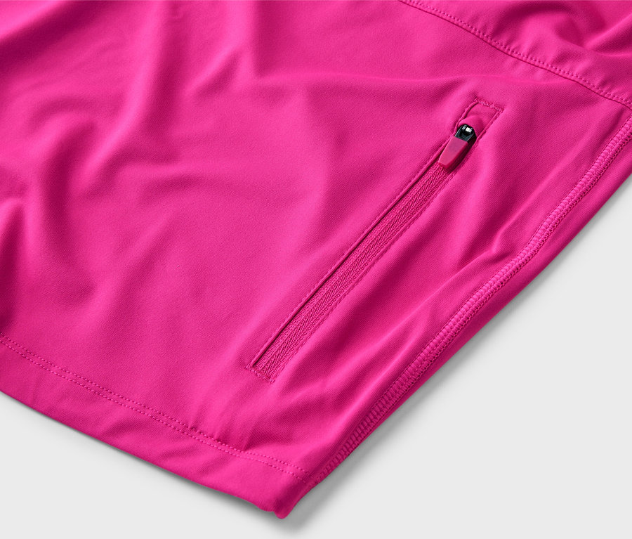 Detail růžové bundy s kapsou na zip.