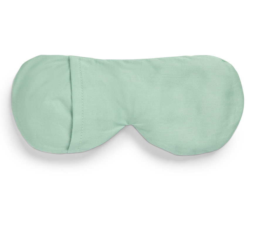 Světle zelená maska na spaní leží na bílém pozadí.