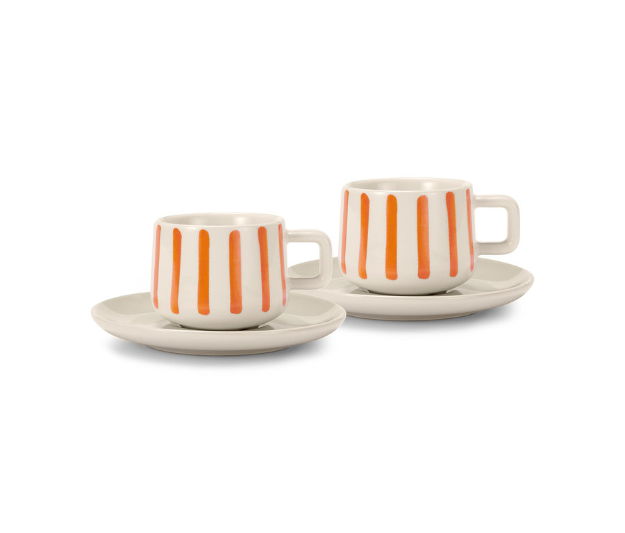 Dva krémové šálky na espresso s oranžovými pruhy a podšálky.
