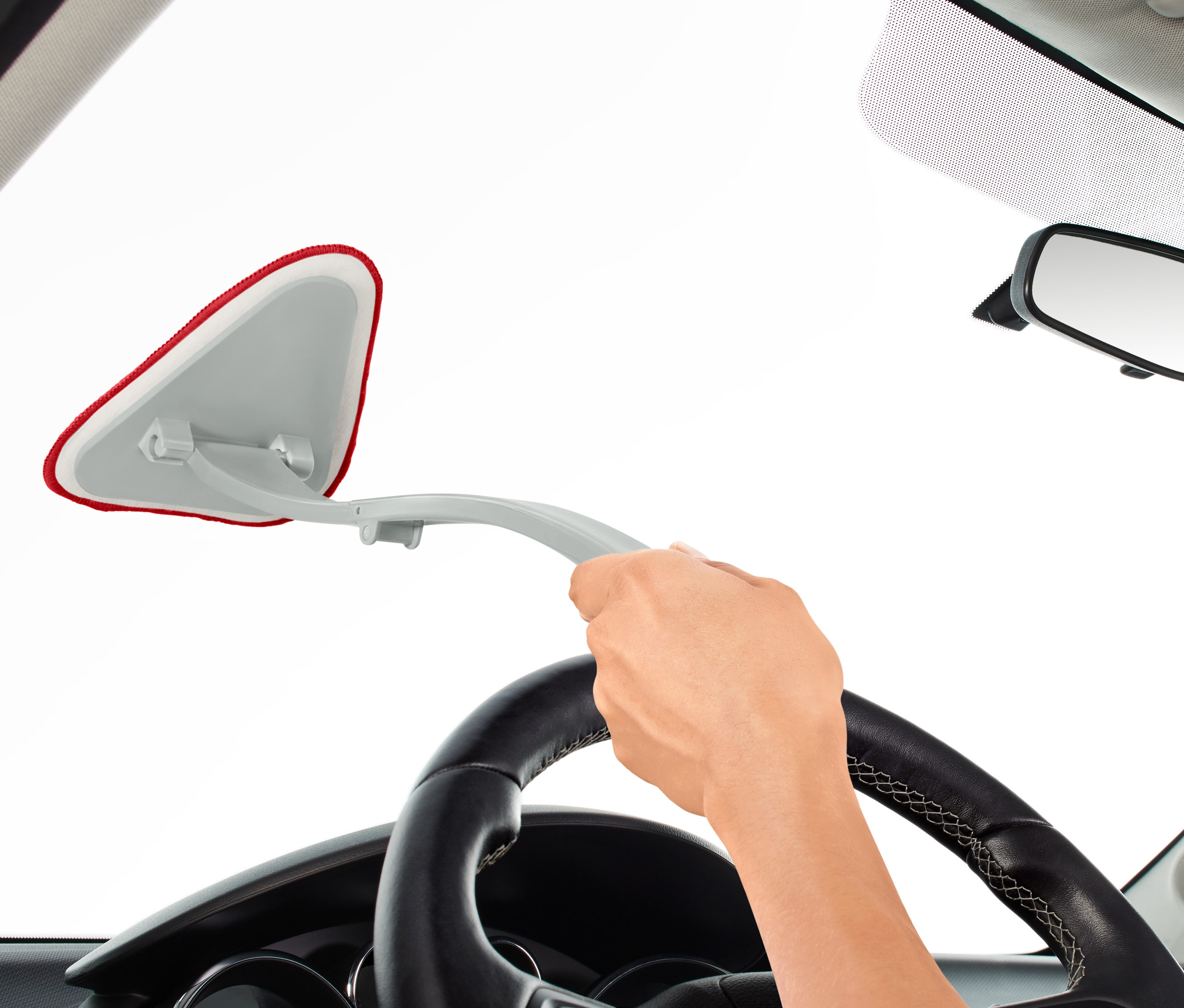 Ruka používá čistič na autoskla zevnitř auta.