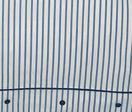 Detail perkálového povlečení s modrými proužky a knoflíky.