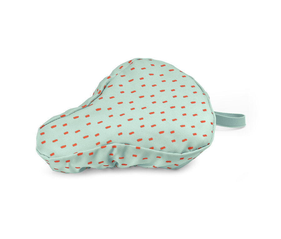 Potah na dětské cyklistické sedlo s oranžovými tečkami na světle zeleném pozadí.