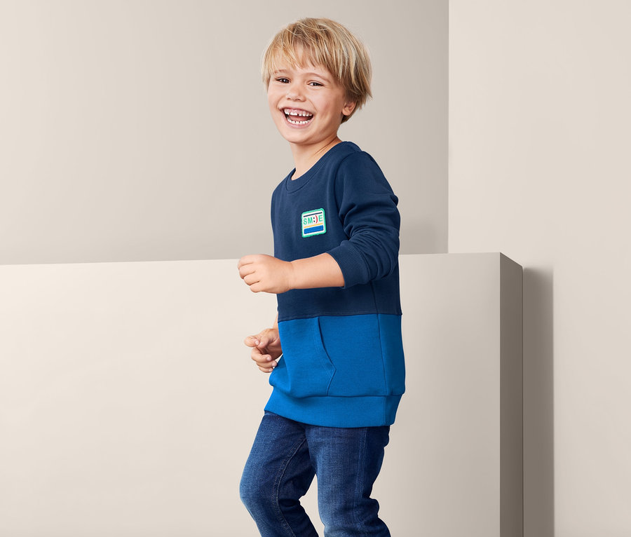 Chlapec má na sobě modrou mikinu.