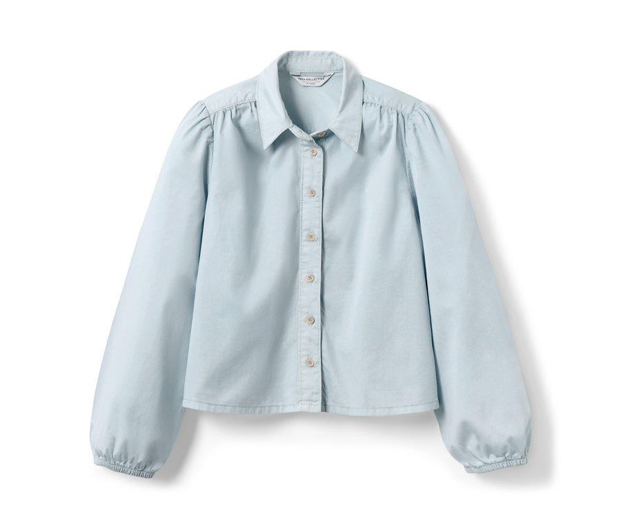 Světle modrá džínová halenka s dlouhými rukávy.