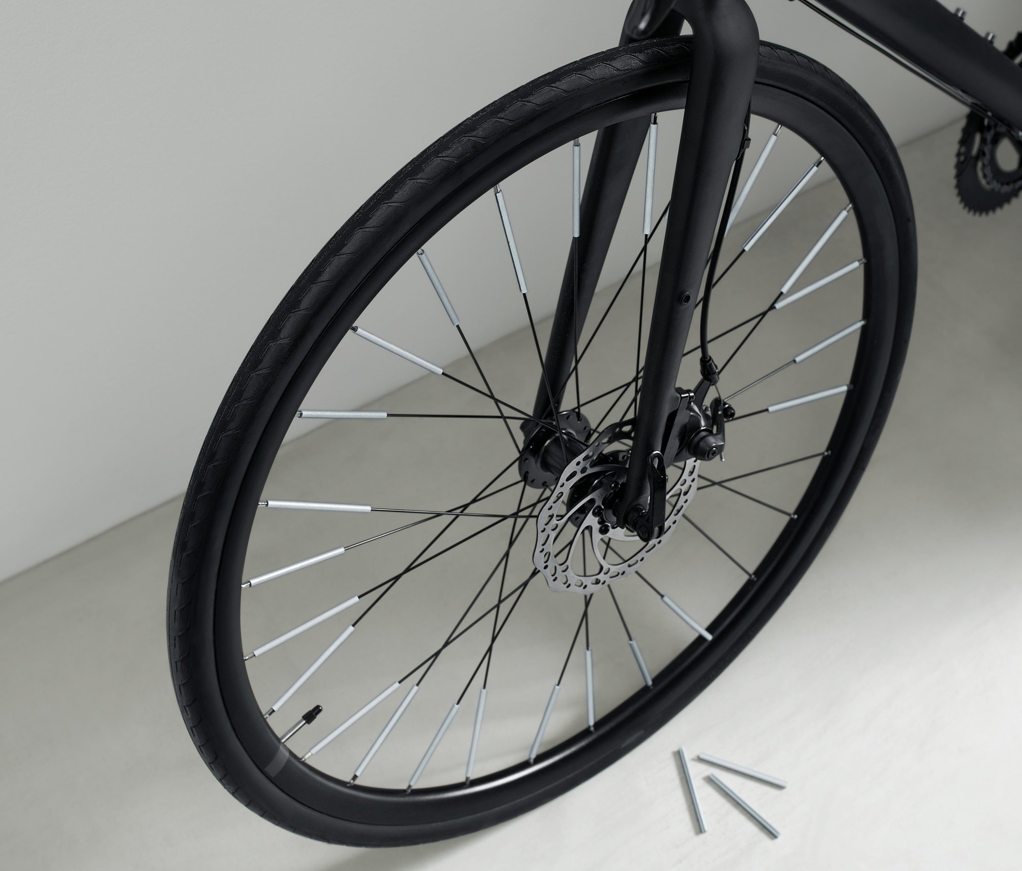 Detailní záběr na černé jízdní kolo s 36 reflexními prvky na paprscích kola.