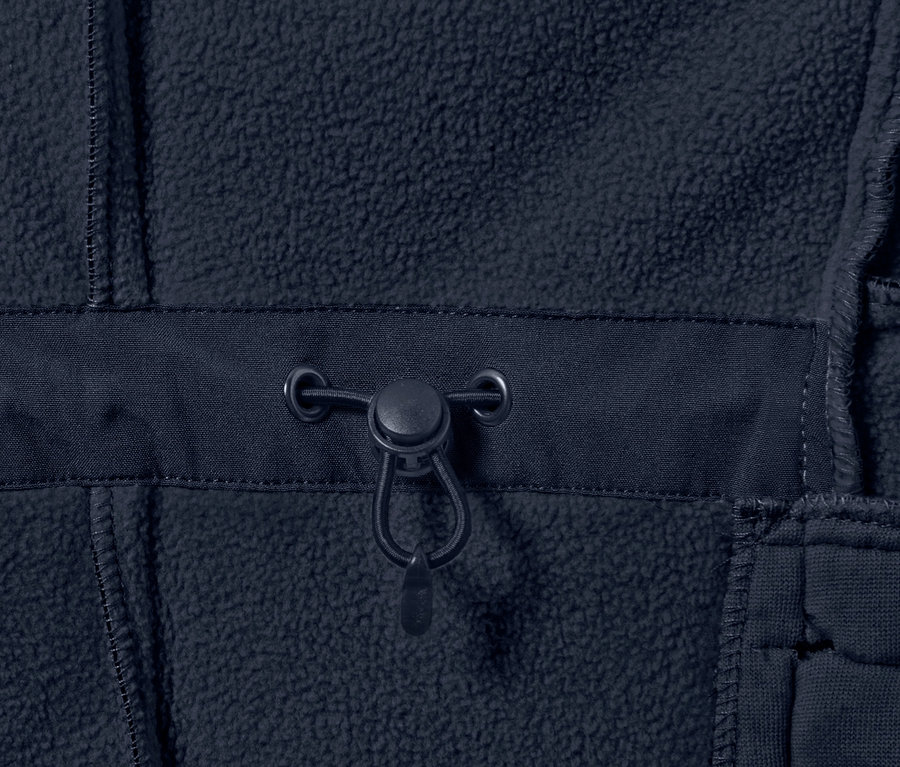 Detailní záběr na tmavě modrý softshellový kabát se stahovací šňůrkou.