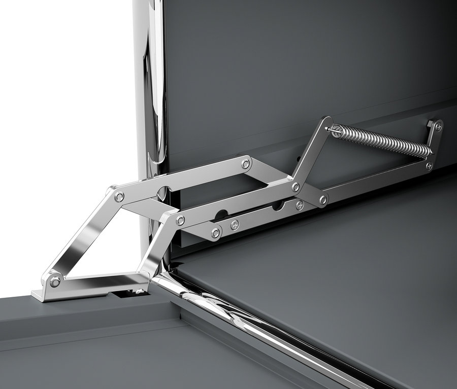 Detail šedé kovové skříňky CN3 s otevřenými výklopnými dvířky, mechanismus uchycení dvířek je stříbrný.