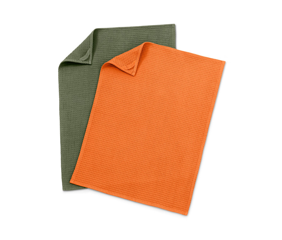 Dva kuchyňské ručníky z vaflového piké: jeden zelený, druhý oranžový.