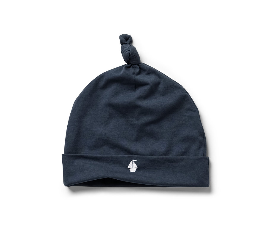 Tmavě modrá čepice se symbolem plachetnice, součást 3dílné soupravy pro miminka.