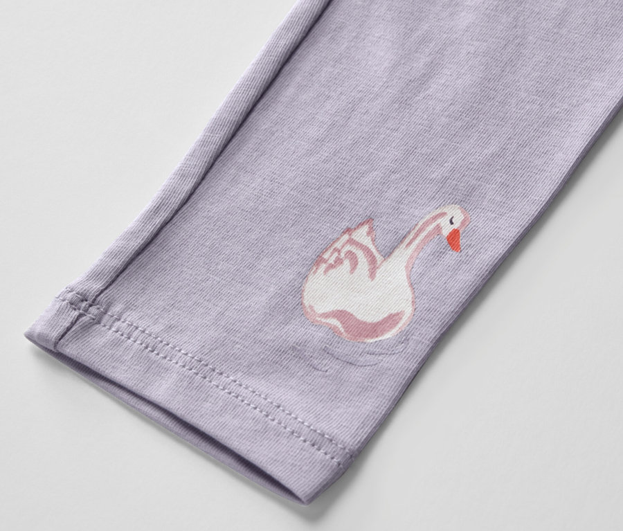 Detail fialových dětských legín s potiskem labutě.