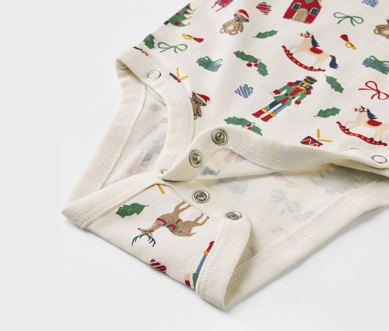 Detail dětského body s vánočním potiskem.