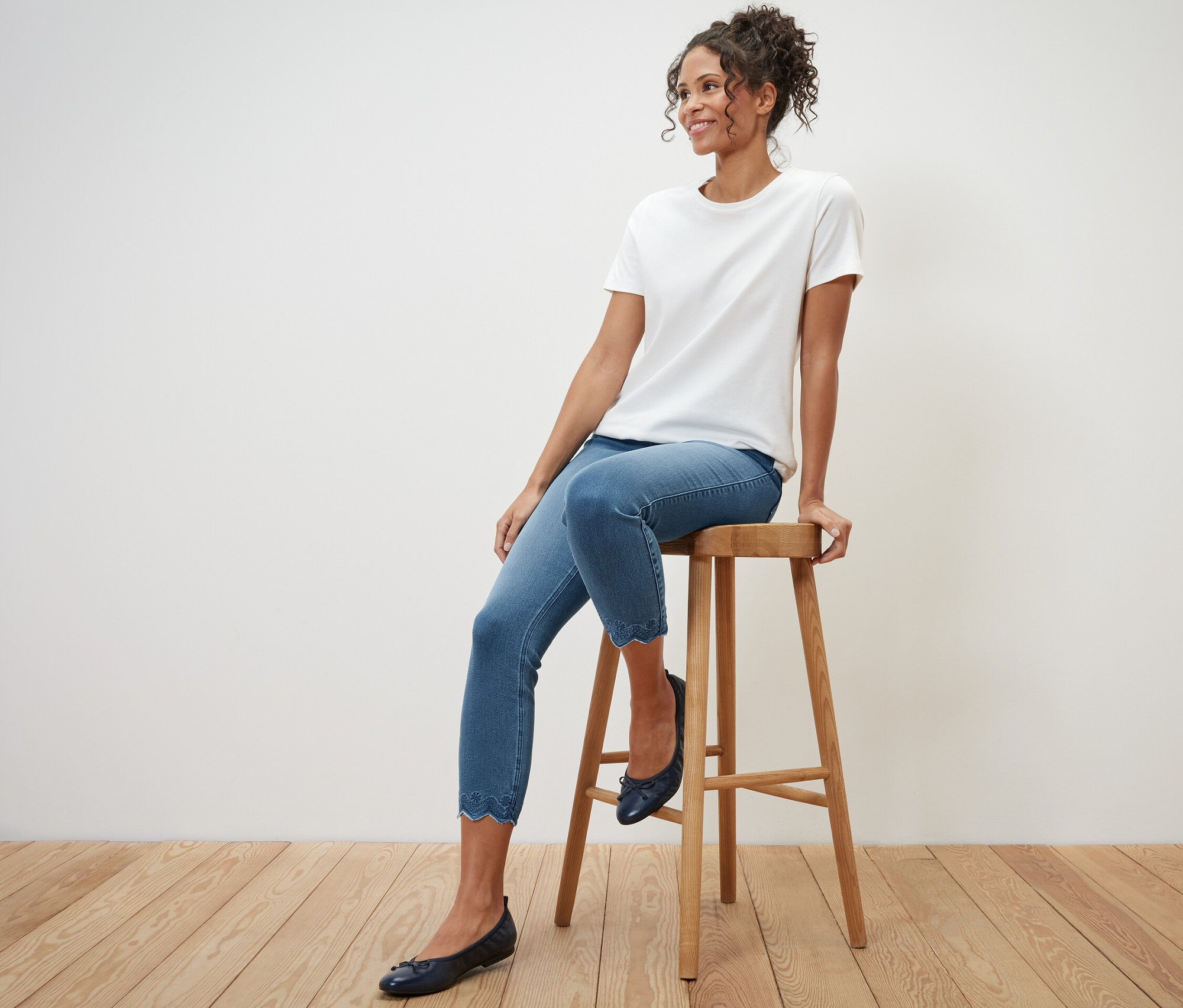 Žena sedí na stoličce a má na sobě 7/8 tregíny s ažurovou výšivkou.