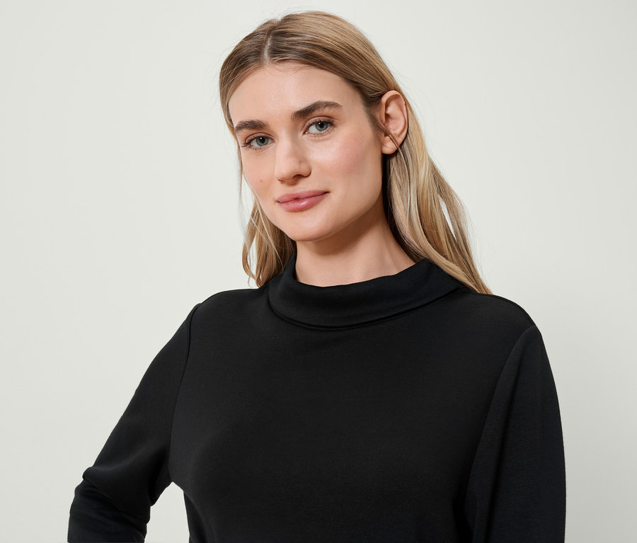 Portrét blondýny v černém roláku.