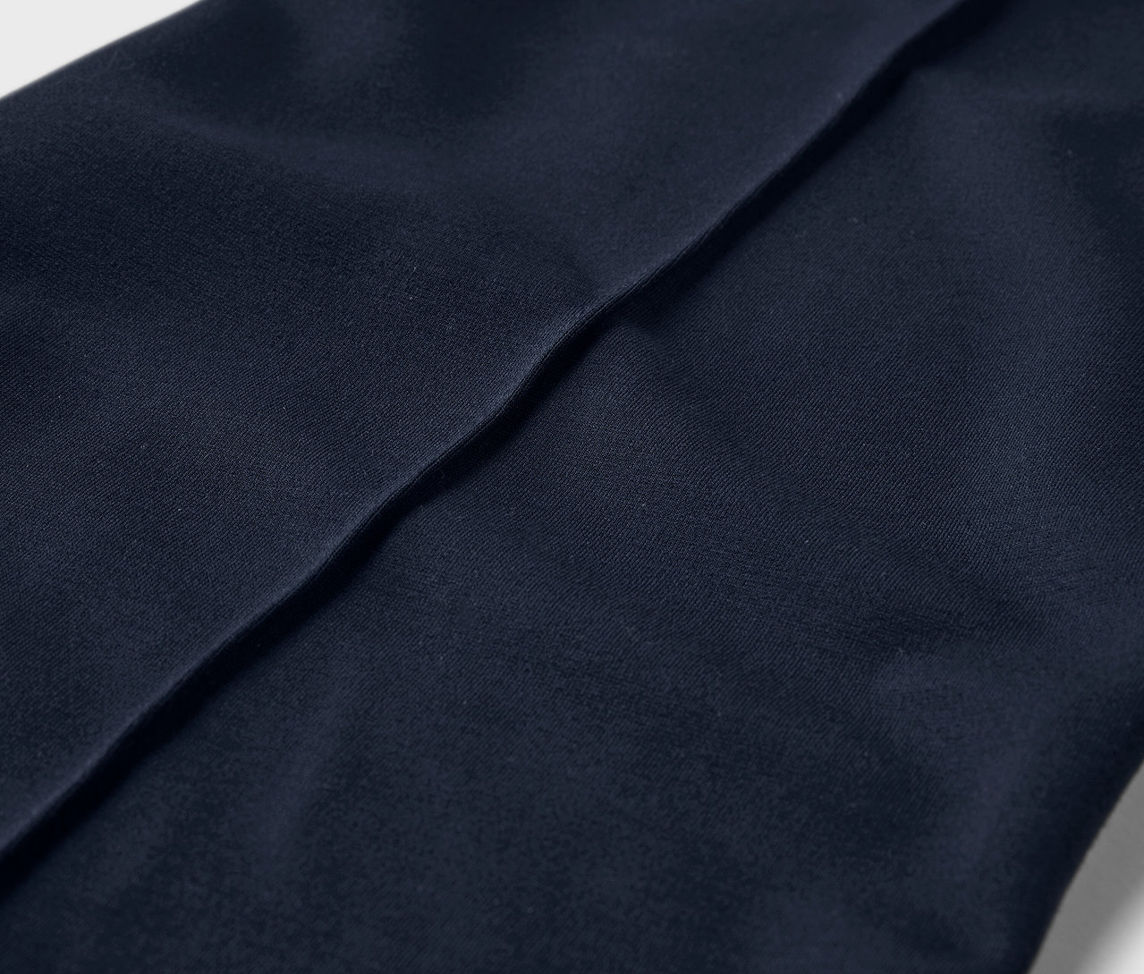 Detailní záběr na žerzejové kalhoty s prošitím.