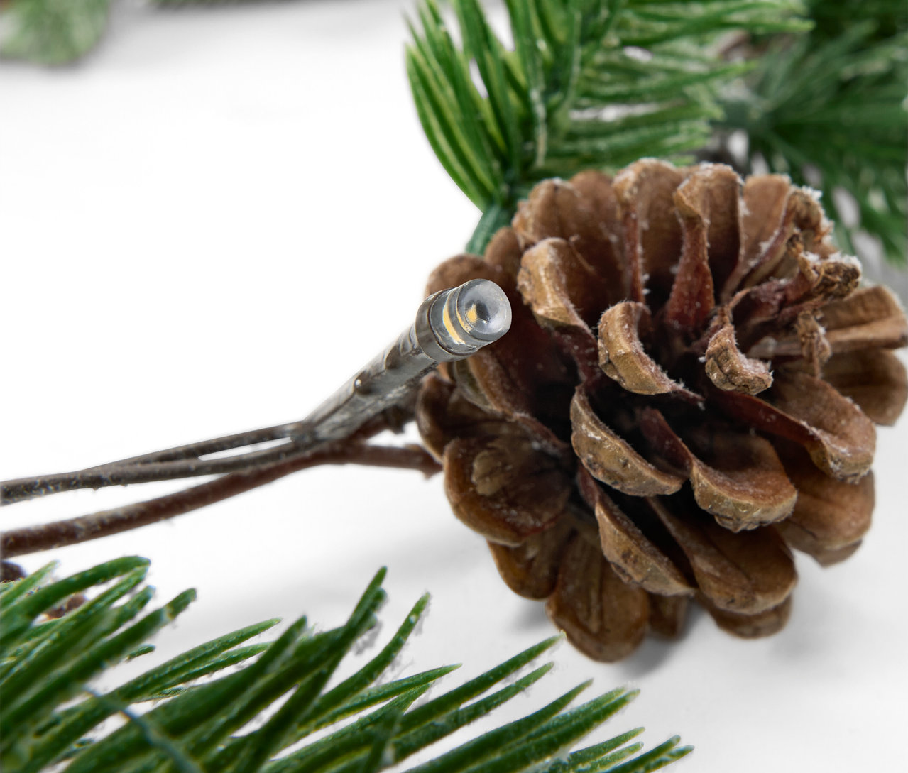 Detail světelného řetězu s šiškou a jehličím.