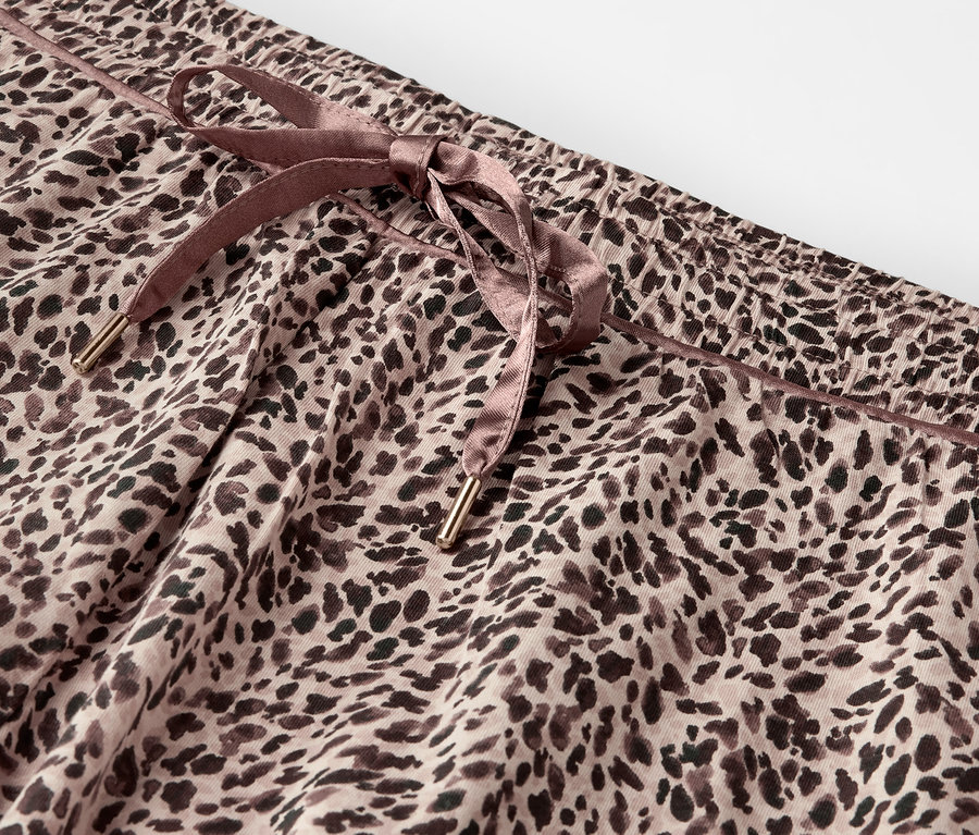 Detail leopardích kalhot s hnědou stahovací šňůrkou.