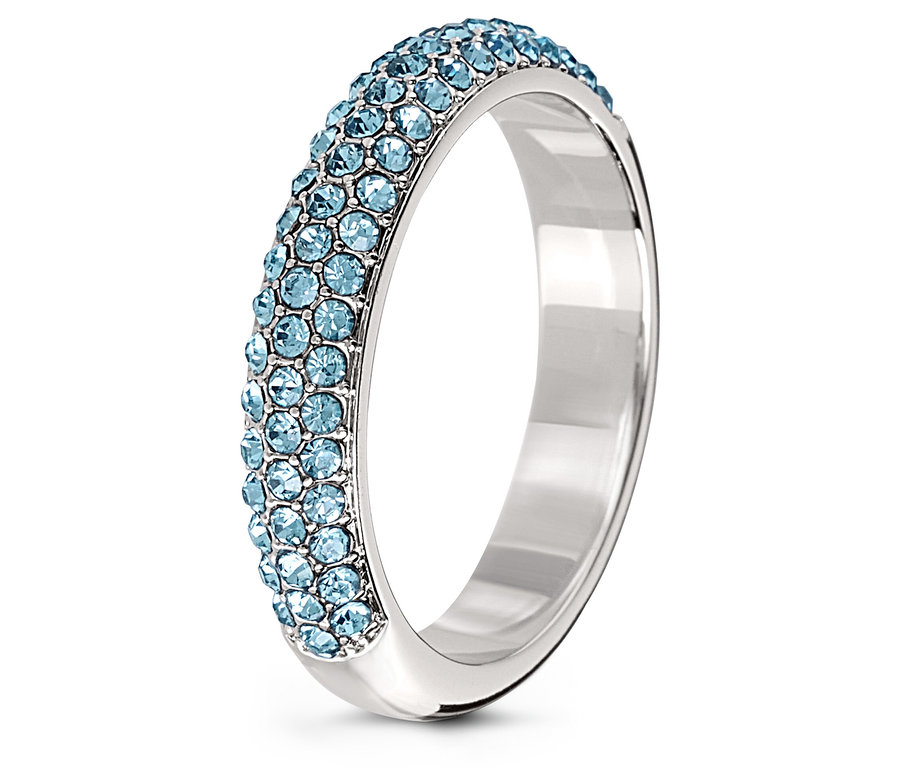 Detail stříbrného prstenu zdobeného světle modrými krystaly.