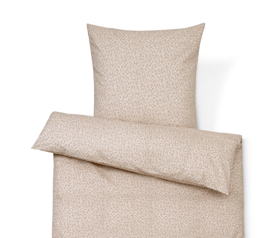 Béžové povlečení s jemným vzorem, skládající se z polštáře, přikrývky a dekorativního polštáře.