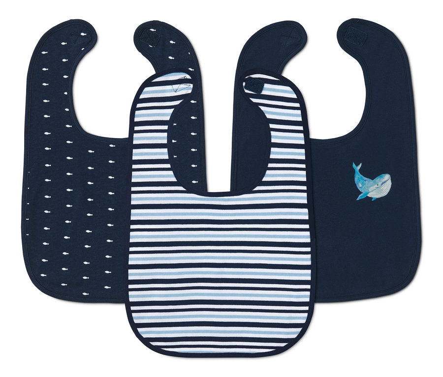 Tři bavlněné bryndáčky: jeden tmavě modrý s bílými rybami, jeden s modrými pruhy a jeden s ilustrací velryby.