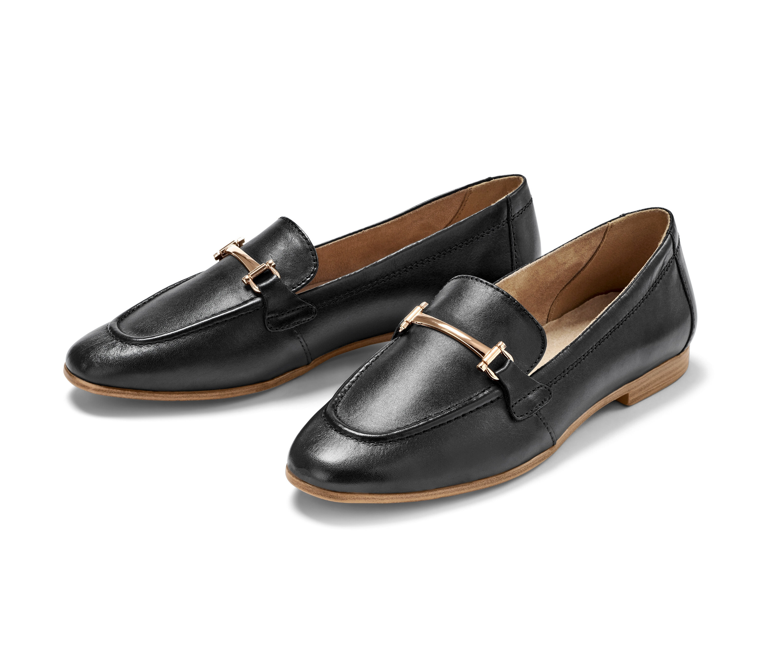 Dvoje černé kožené mokasíny s ozdobnou sponou leží vedle sebe.