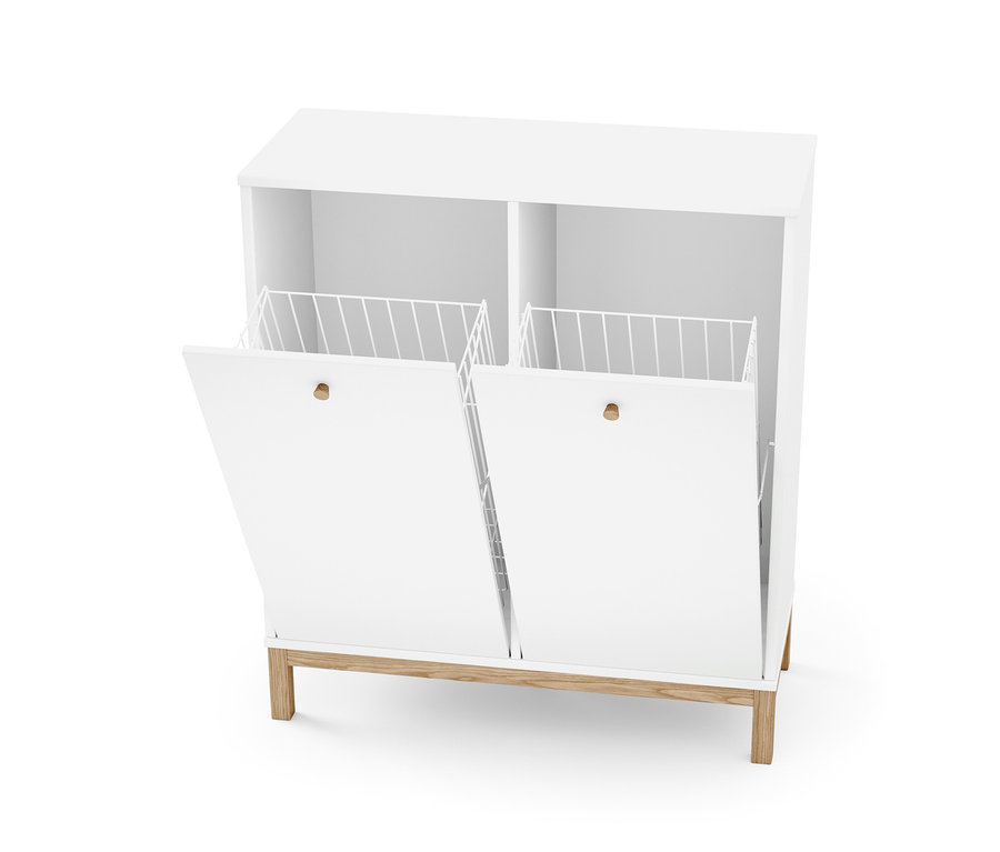 Bílý regál s košem na prádlo má otevřená dvířka s drátěným košem.