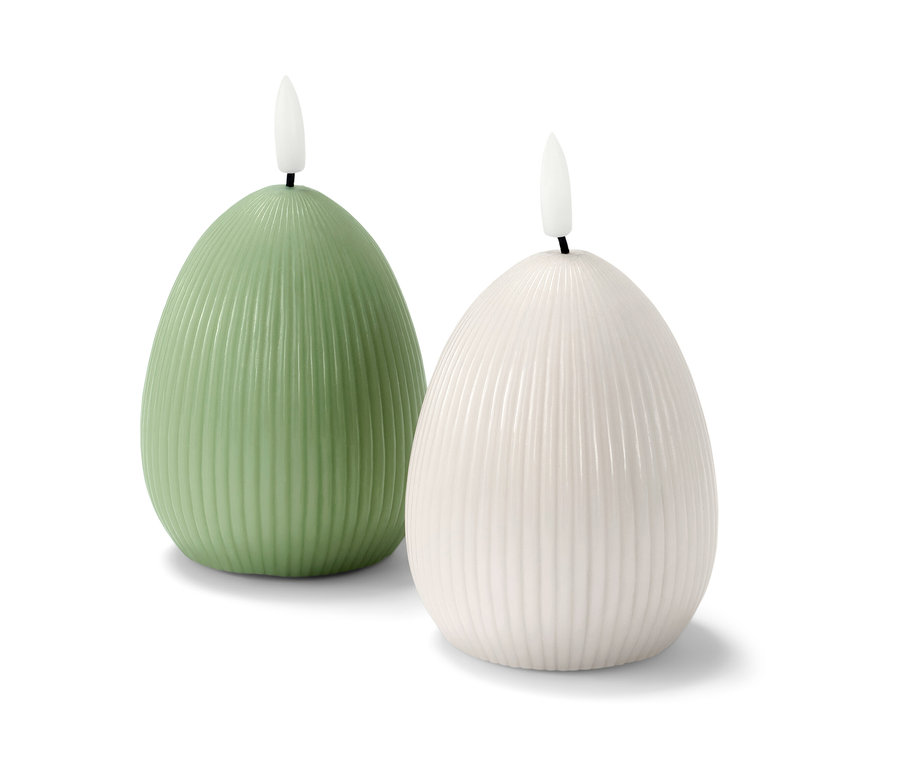 Dvě LED svíčky z pravého vosku, jedna zelená a jedna bílá, stojí vedle sebe na bílém pozadí.