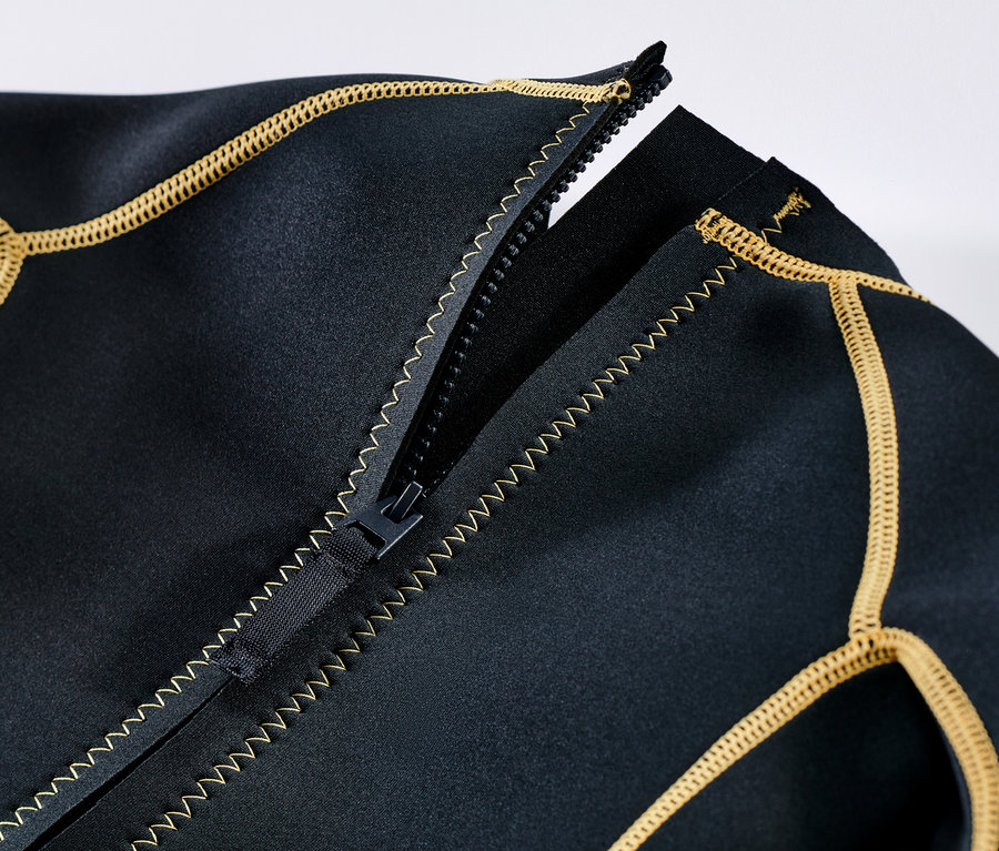 Detail dětského neoprenového obleku s rozepnutým zipem a žlutým lemováním.