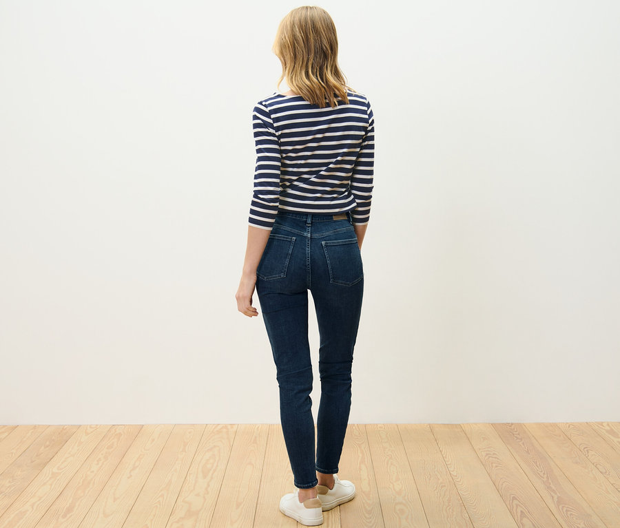 Žena stojí zády k fotoaparátu a má na sobě skinny džíny »Hanna«.
