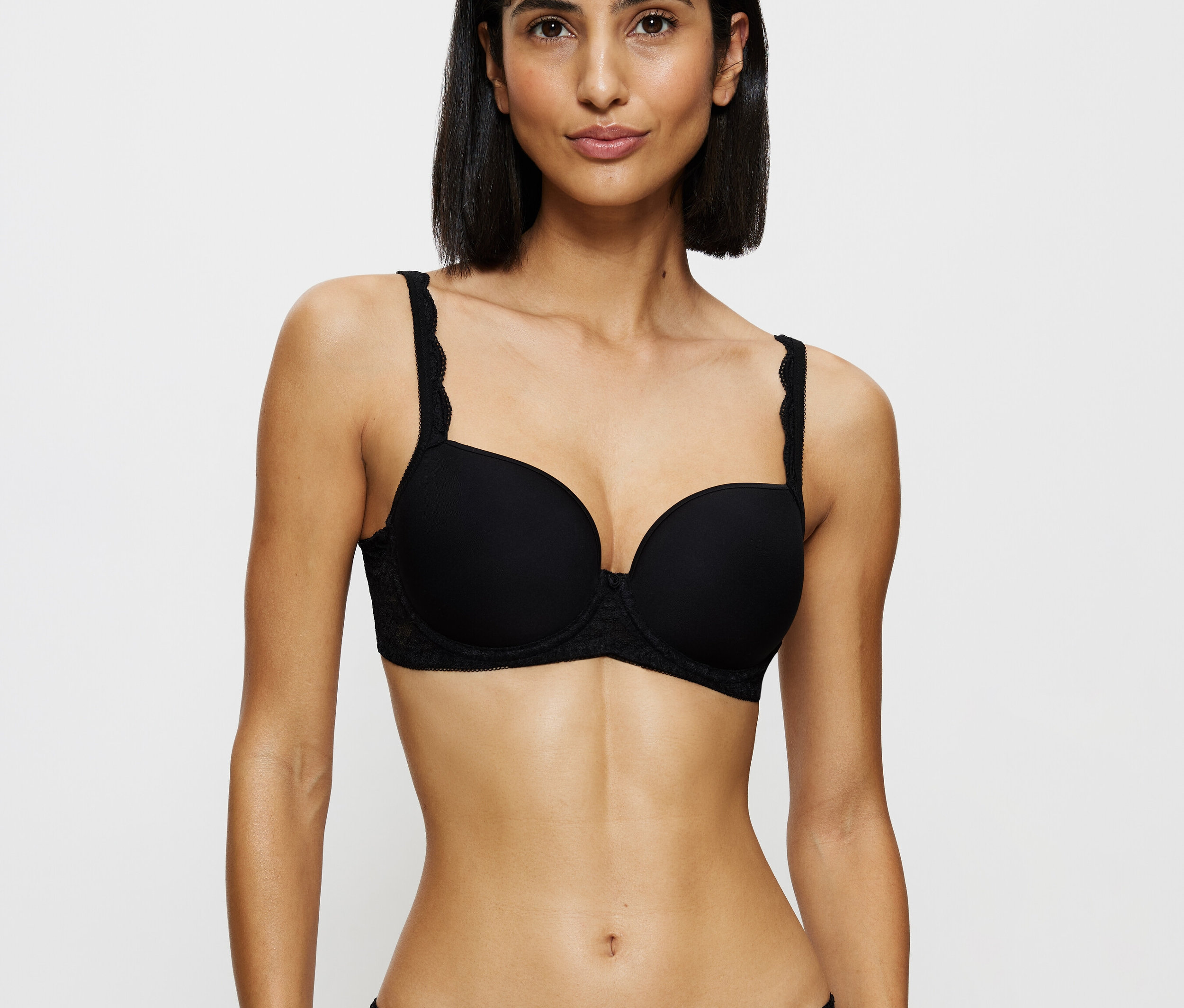 Žena má na sobě černou krajkovou podprsenku a kalhotky.