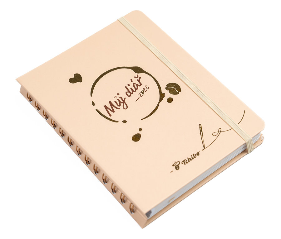 Detailní záběr na světle růžový diář 'Můj diář 2026' s elastickým uzávěrem.