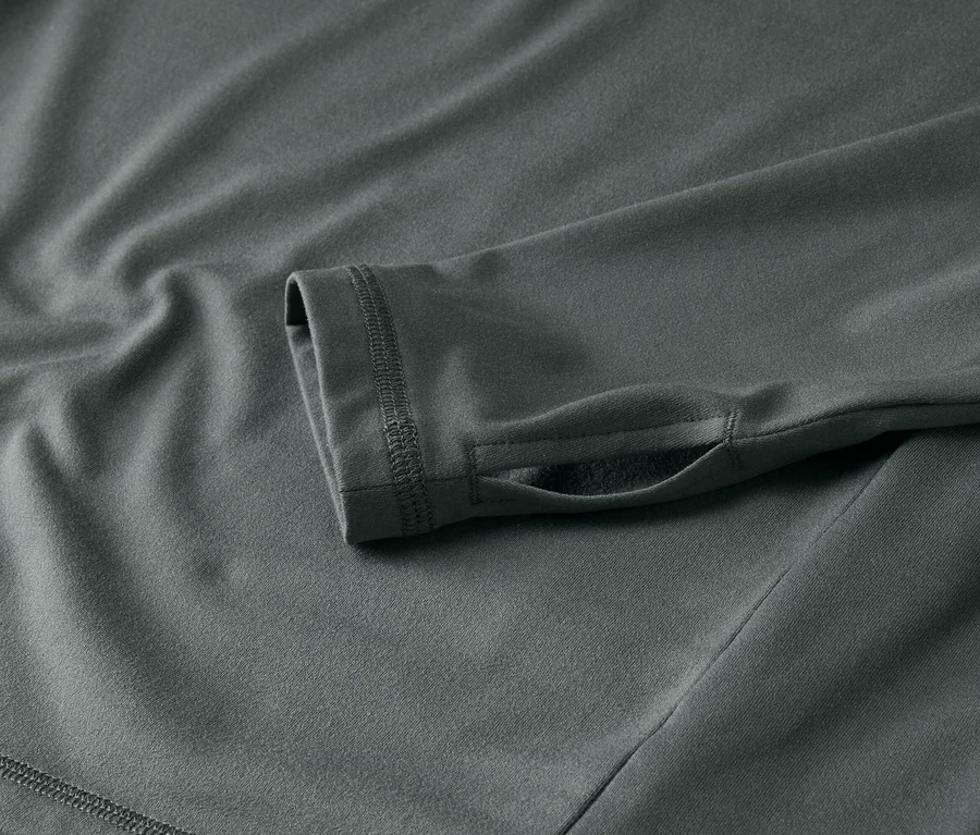 Detail šedého trika s dlouhým rukávem a otvorem na palec.