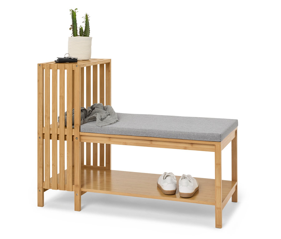 Bambusový regál na boty s lavicí a čalouněným sedákem, na kterém je rostlina, klíčenka a šála.