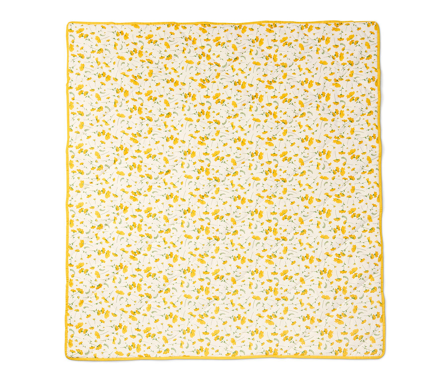Bílá vatovaná pikniková deka s drobnými žlutými květy a žlutým lemem.