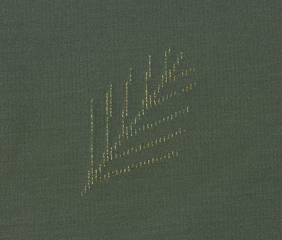 Detail zeleného žakárového ubrusu.