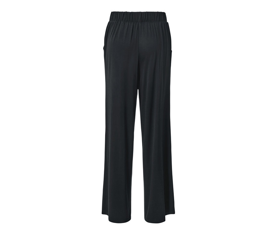 Detail zadní strany černých kalhot se širokými nohavicemi.