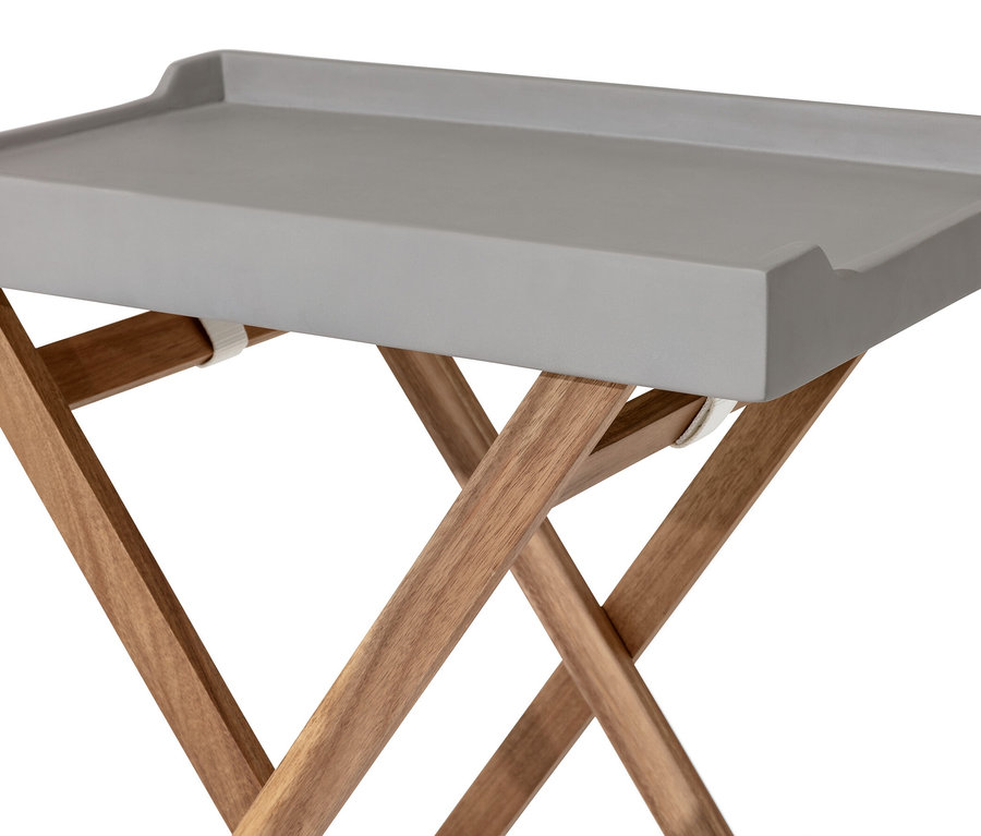 Detail šedého stolku s polycementovou deskou a dřevěnýma nohama.