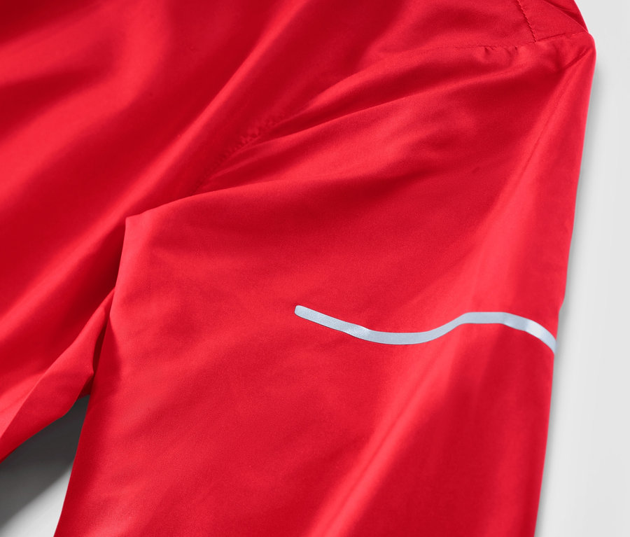 Detail červené lehké běžecké bundy.
