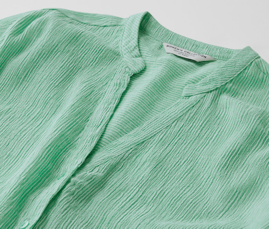 Detail zelené proužkované tuniky.