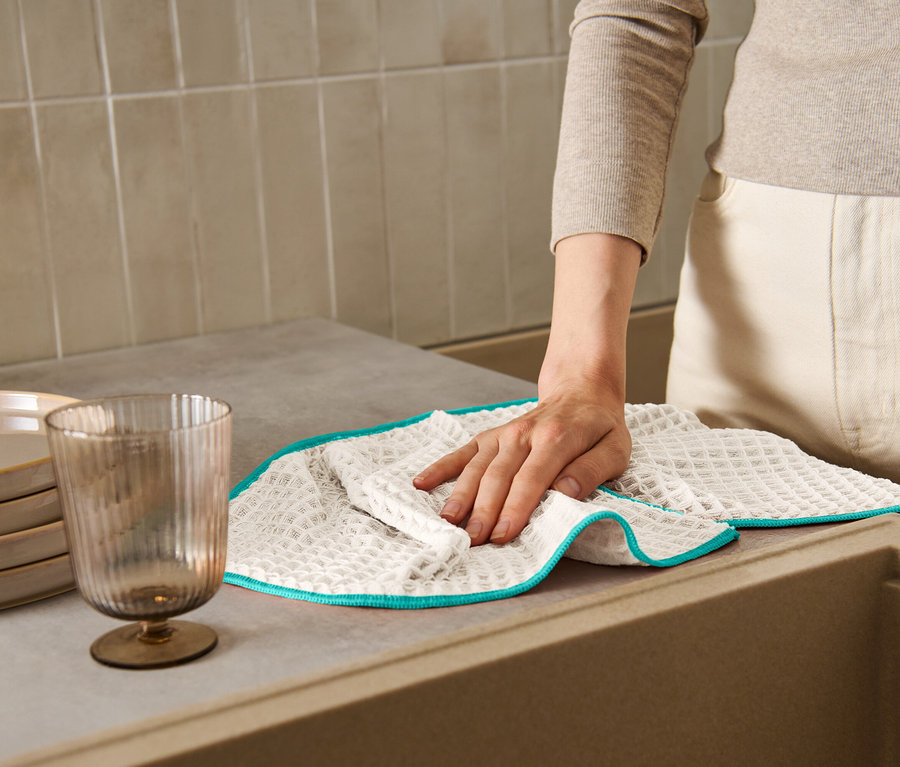 Žena utírá linku extra velkou sušicí utěrkou.