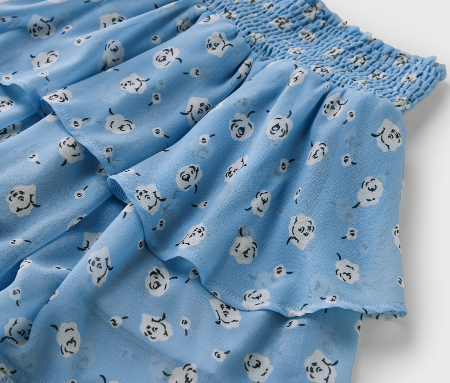 Detail dívčí stupňovité sukně s květinovým potiskem.